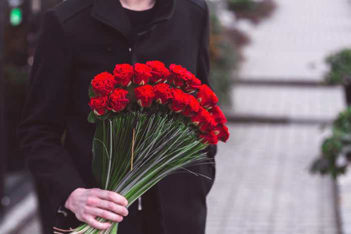 kaboompics-com_young-man-holding-one-big-beautiful-bouquet-of-many-red-rose-flowers